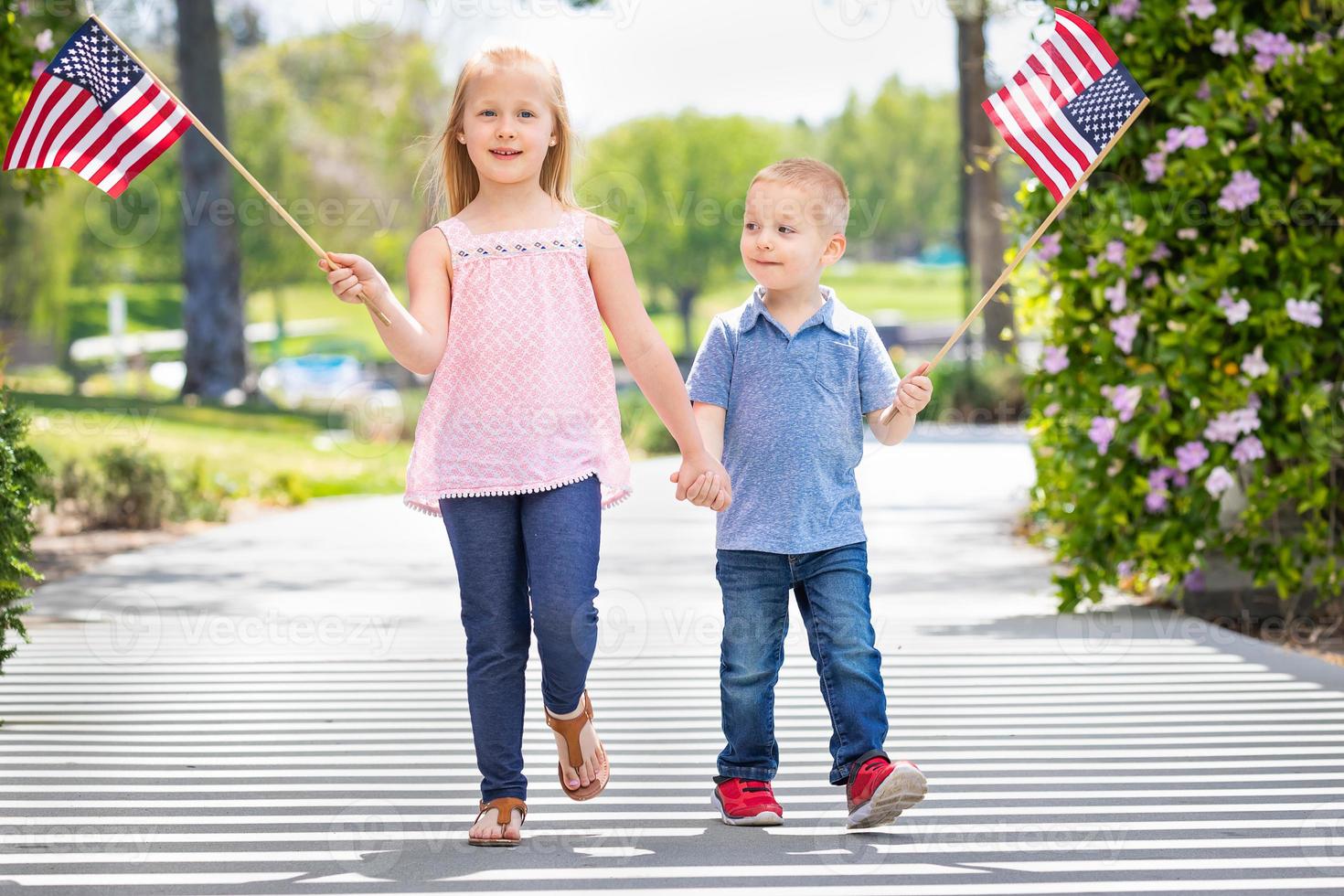 Young Sister and Brother Waving American Flags At The Park photo