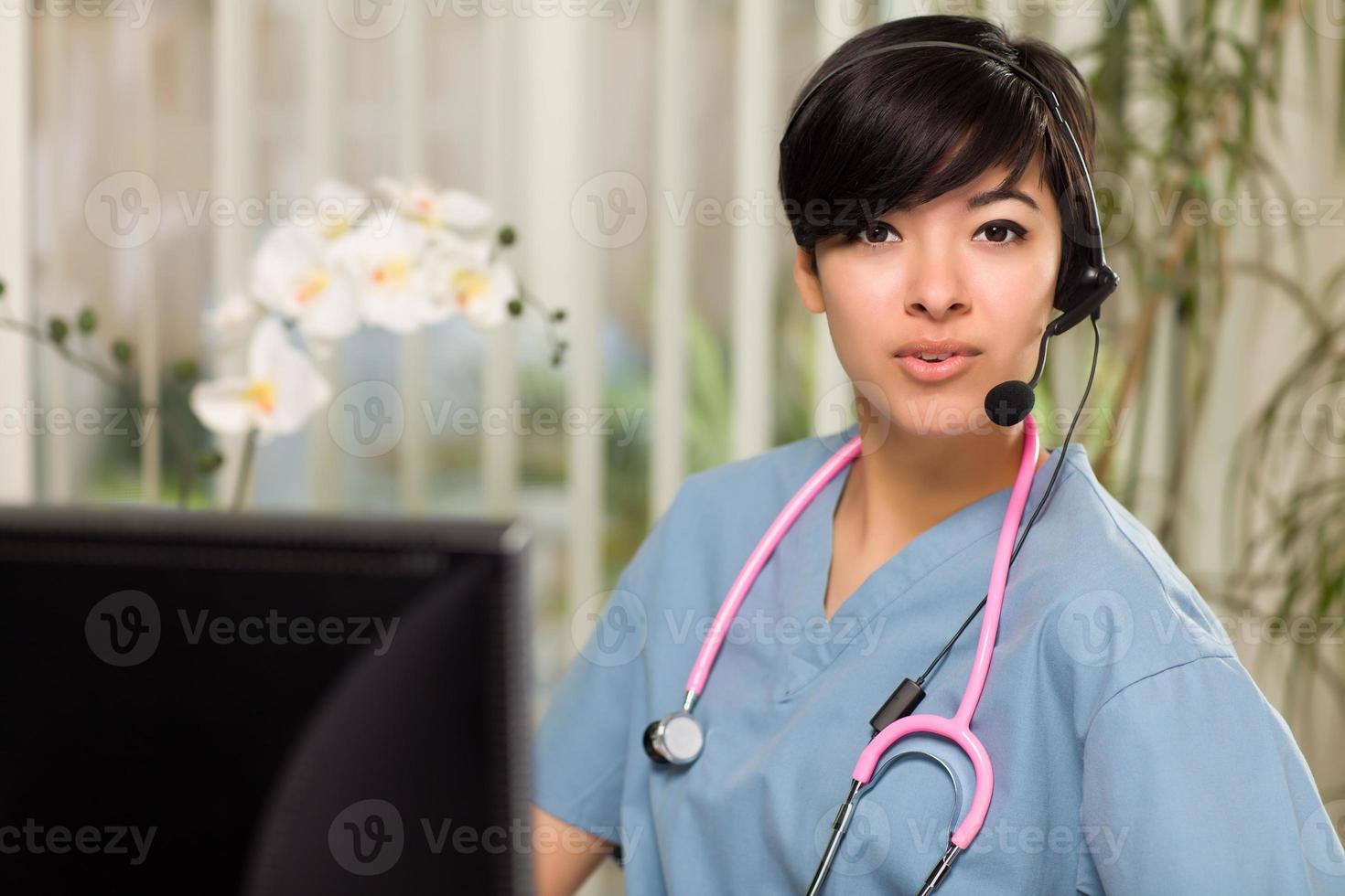 Attractive Multi-ethnic Woman Wearing Headset, Scrubs and Stethoscope photo