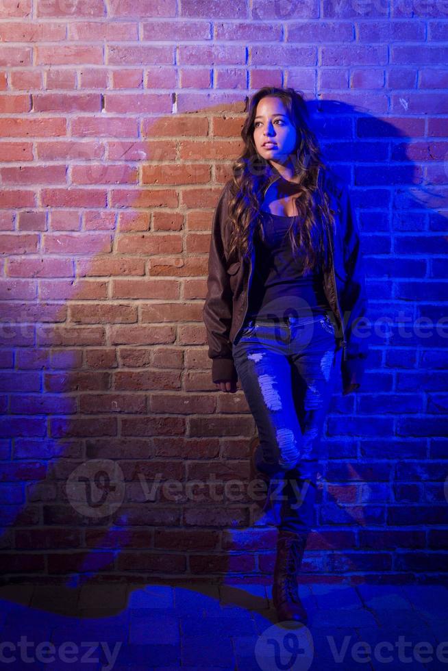 Pretty Mixed Race Young Adult Woman Against a Brick Wall photo