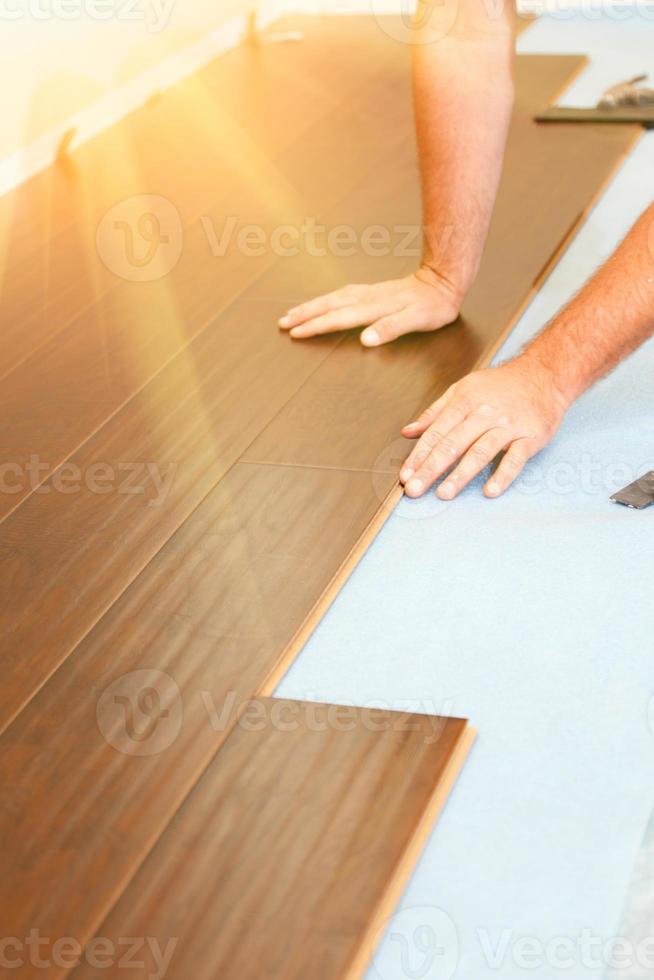Man Installing New Laminate Wood Flooring photo