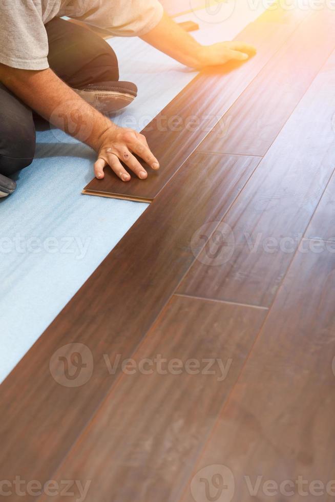 Man Installing New Laminate Wood Flooring photo