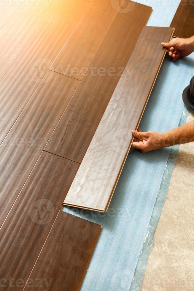 Man Installing New Laminate Wood Flooring photo