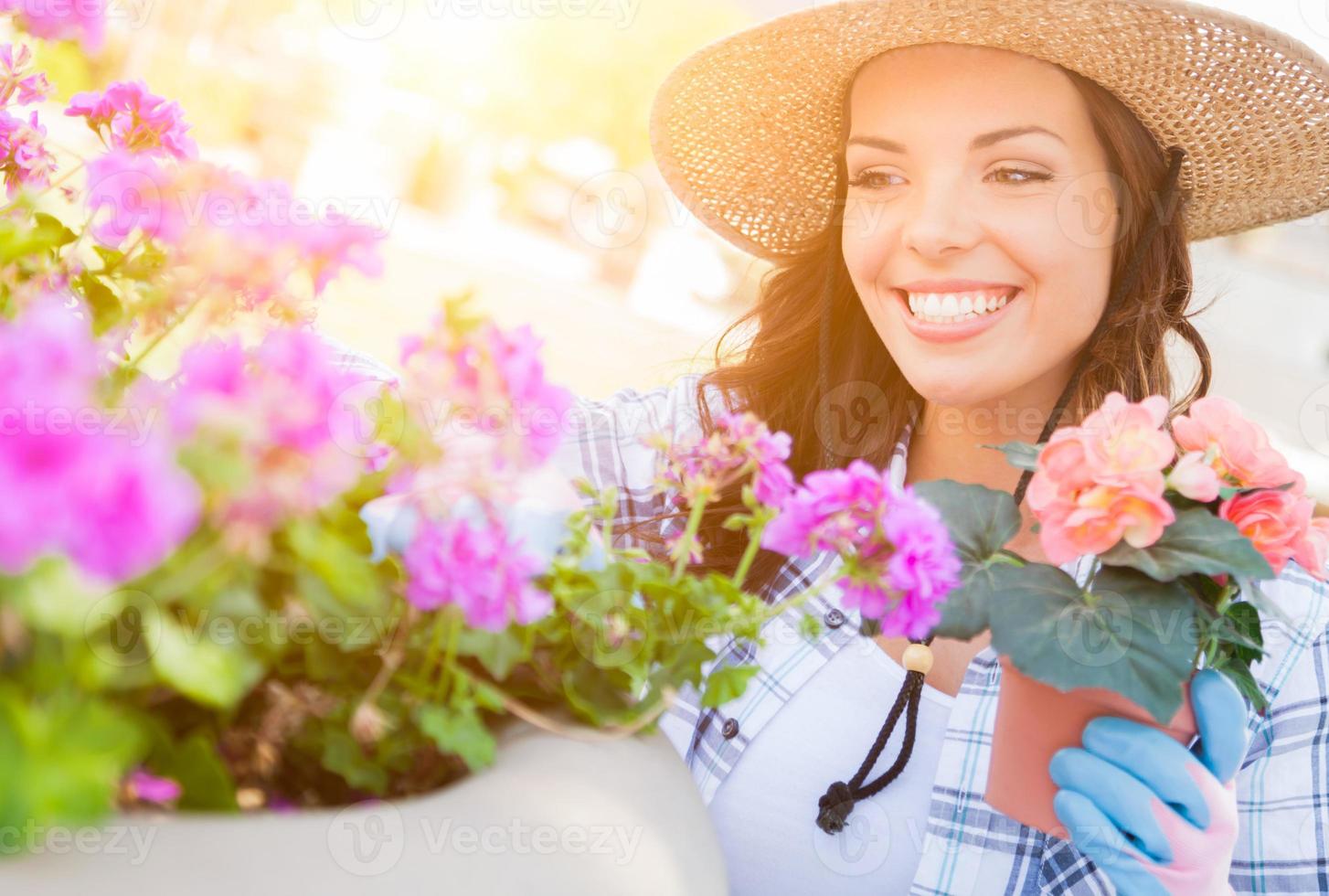 mujer adulta joven con sombrero y guantes de jardinería al aire libre foto