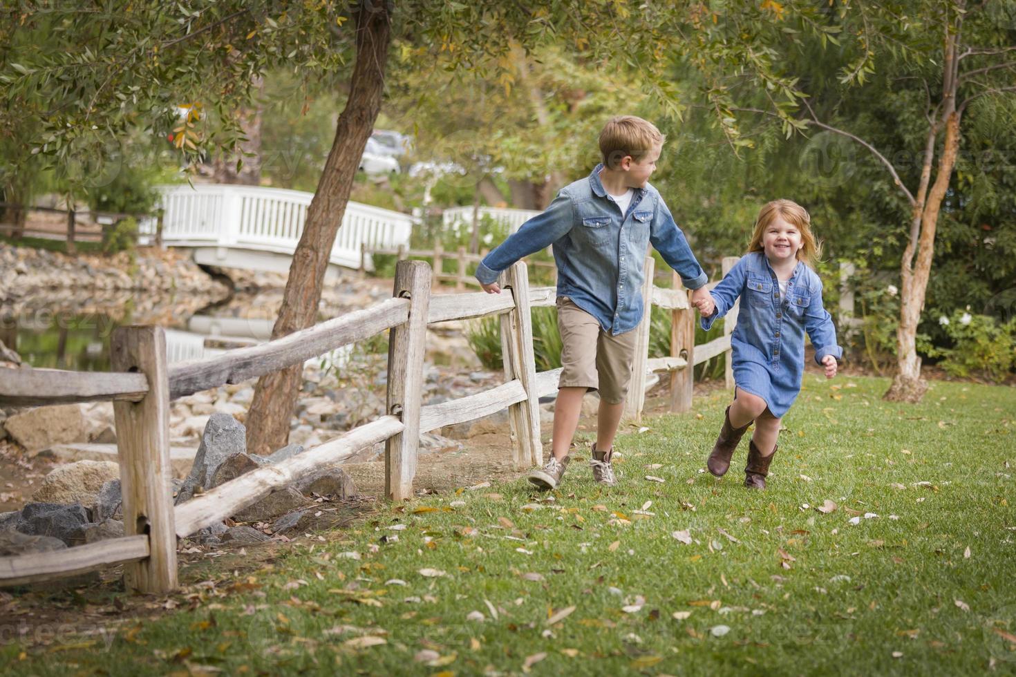 Happy Young Brother and Sister Running Outside photo