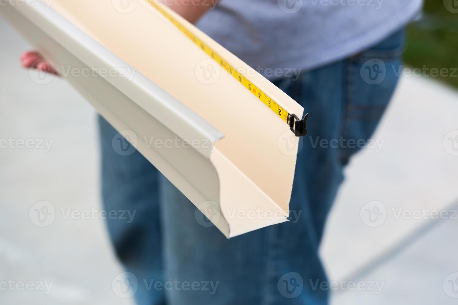 Worker Measuring Rain Gutter Processing Through Seamless Shaping Machine photo