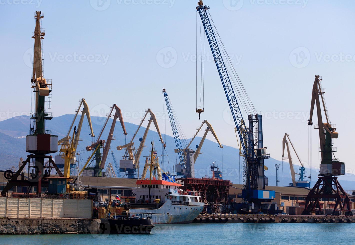 grúas y barcos en un puerto. foto