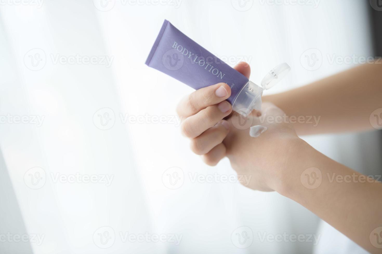 Close up of women applying body lotion cream on hand. photo