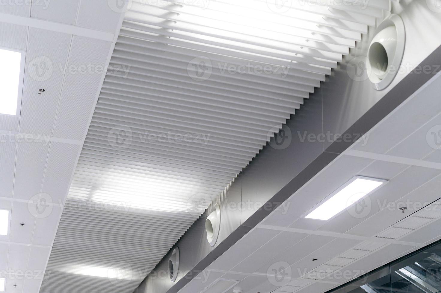 Ceiling mounted cassette type air conditioner and modern lamp light on white ceiling. duct air conditioner for home or office photo