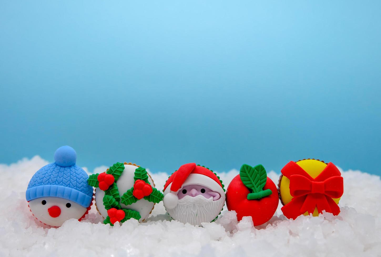 There are Christmas concept, santa clause, snowman are on the fake snow with colorful background. They are so cute and this photo has space for text.