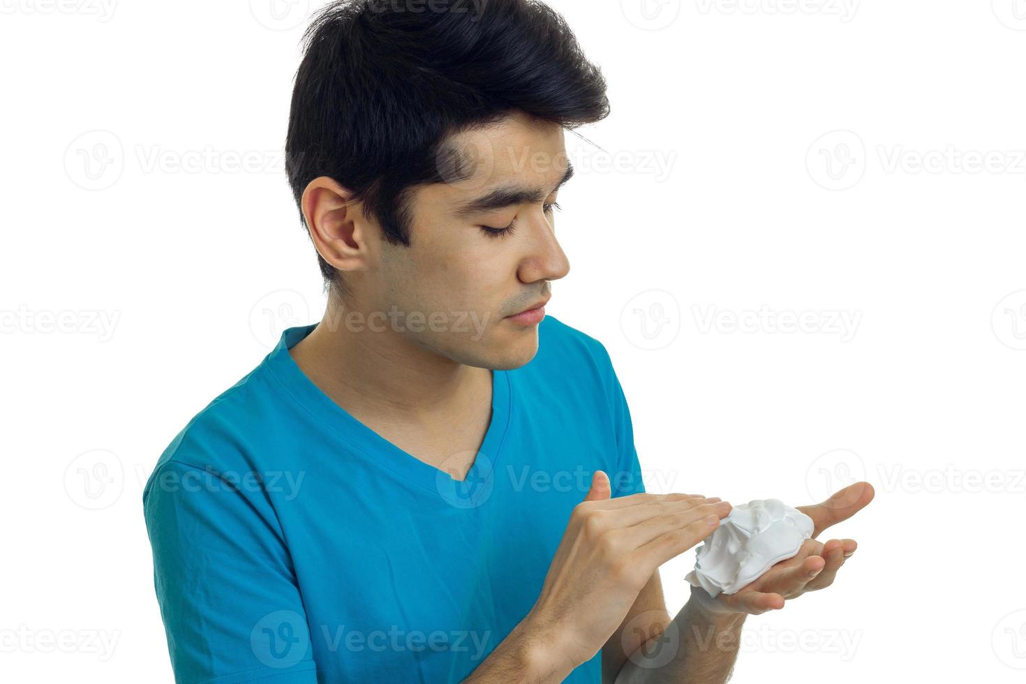 close-up portrait of a guy in a t-shirt which seriously impair shaving foam on hand photo