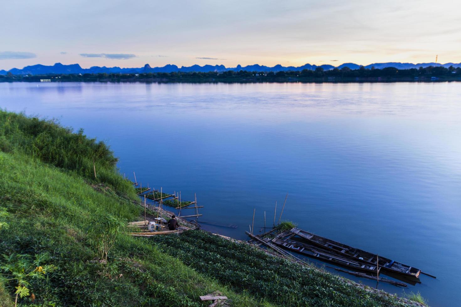 Vegetable plots along the banks of the Mekong River with farmers tending them against the colorful Mekong river view in the morning. photo