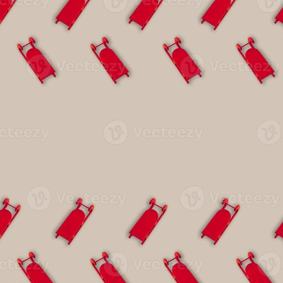 Christmas pattern with red sleighs against beige background. Minimal winter holiday wrap design with copy space. Flay lay concept. photo
