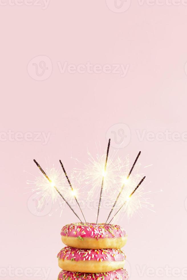 Doughnut cake with sparklers on a pink background. Minimal composition. Party creative idea. photo