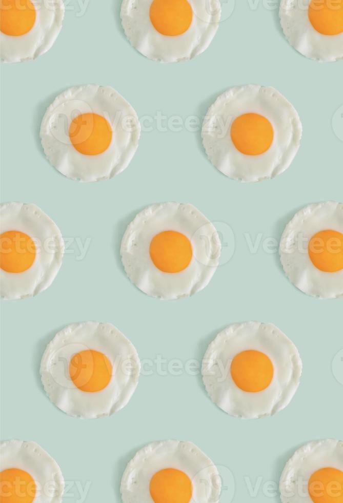 Flat lay pattern with poached eggs on a light mint green background. Minimal concept food concept. Trendy mockup or a wallpaper. photo