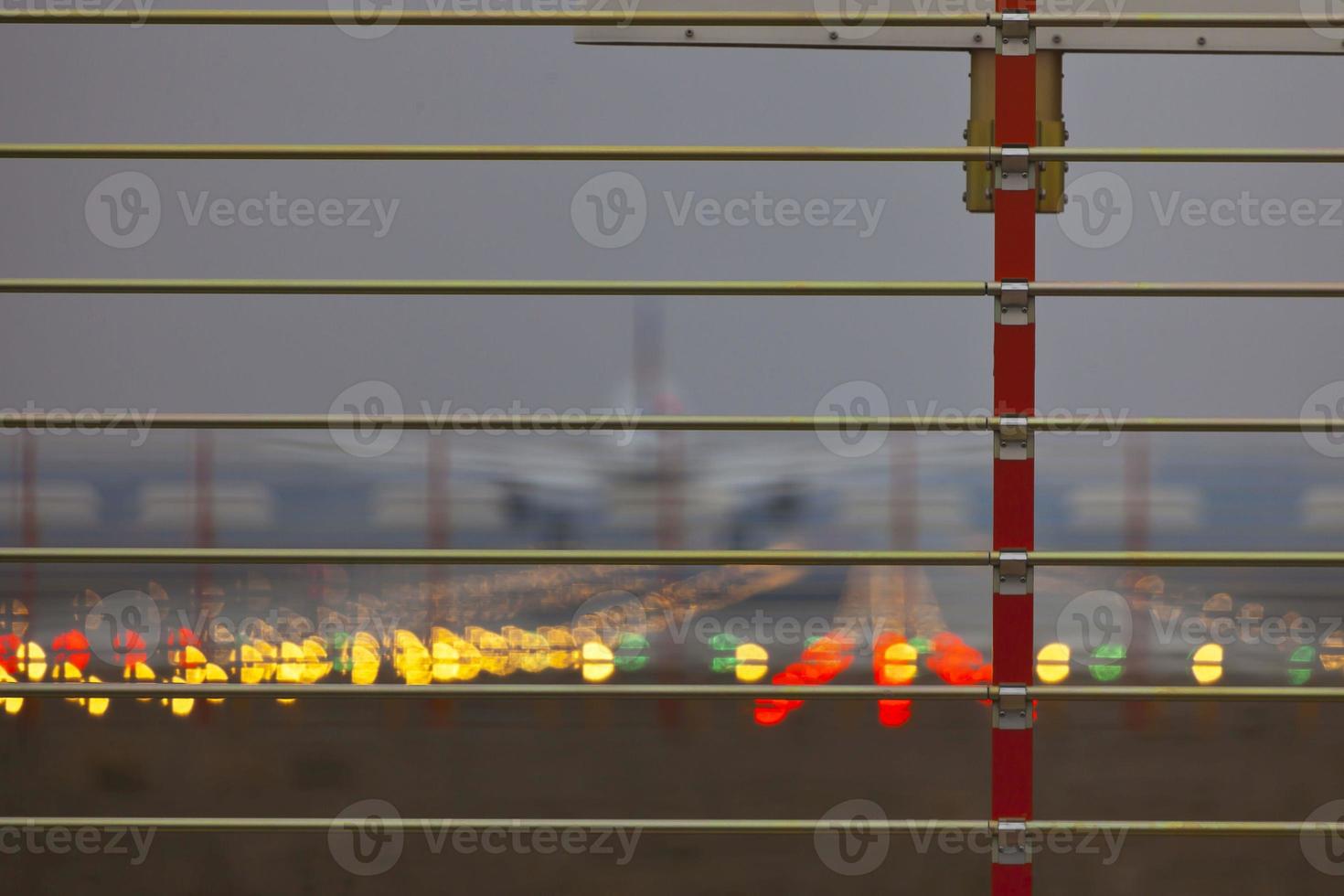 Security fence at an airport with airplane in background photo