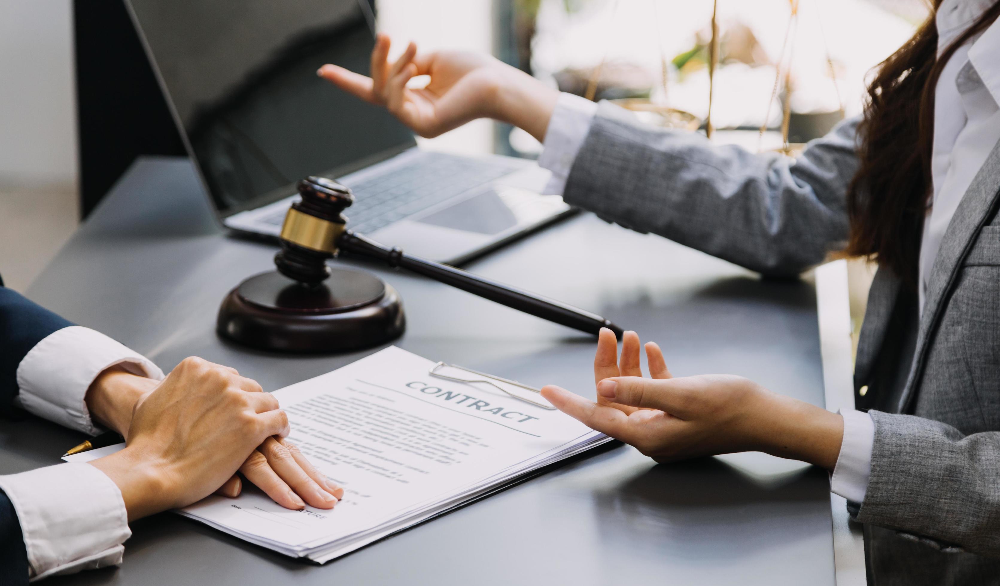 abogado masculino que trabaja con papeles de contrato y mazo de madera en tabel en la sala del