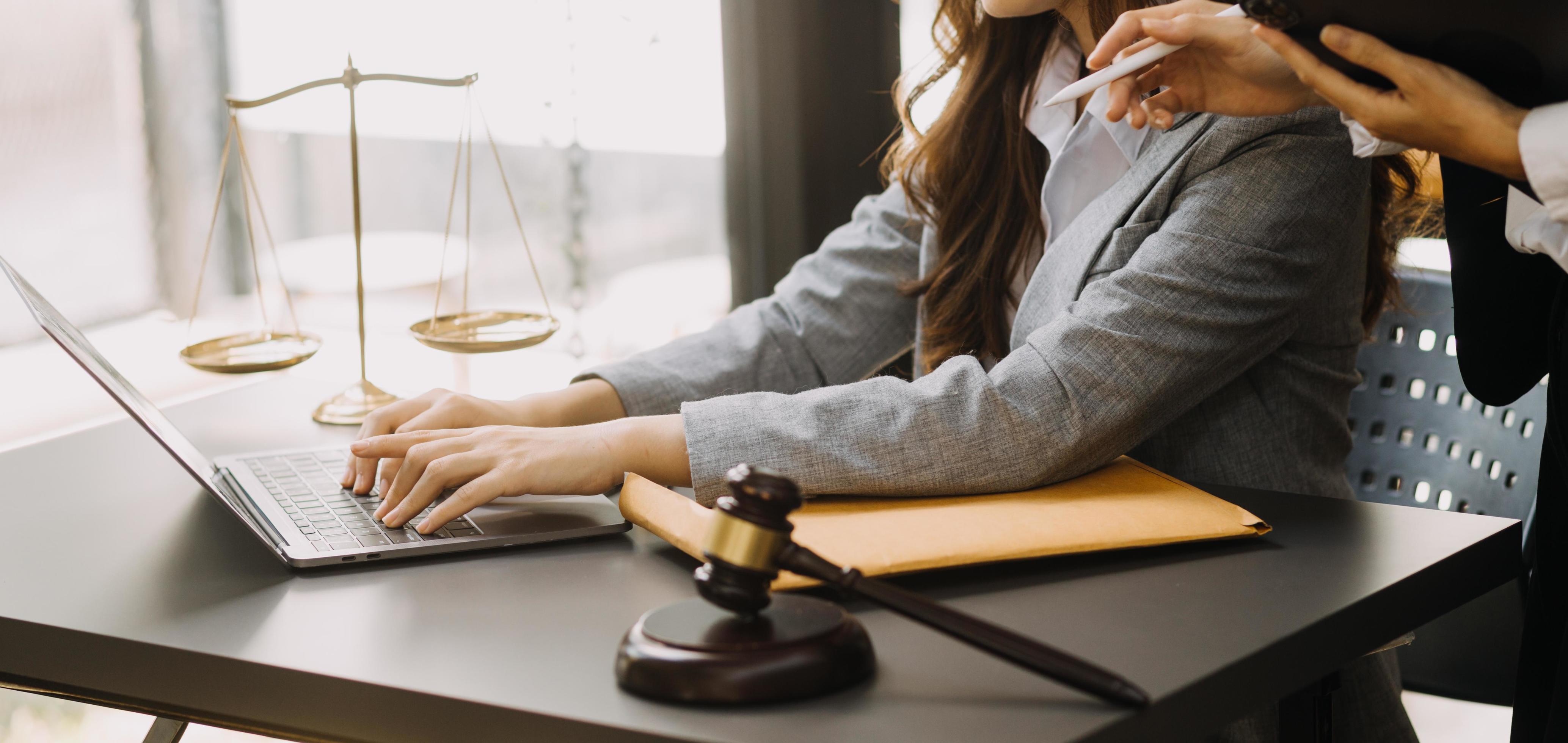 abogado masculino que trabaja con papeles de contrato y mazo de madera en tabel en la sala del