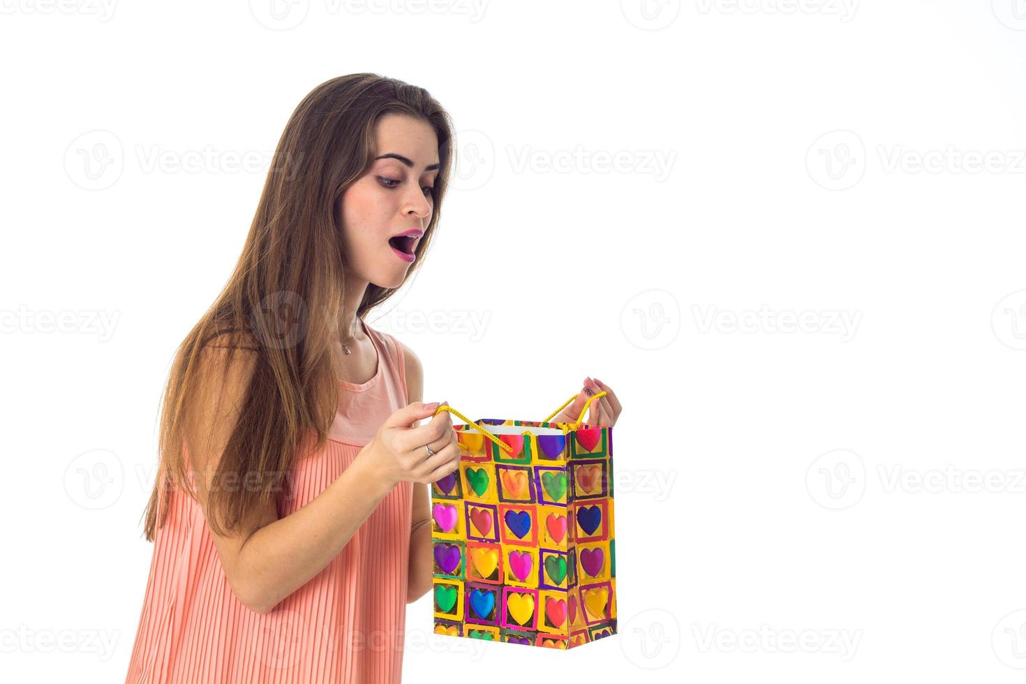 young girl looks at color package and wonders is isolated on  white background photo