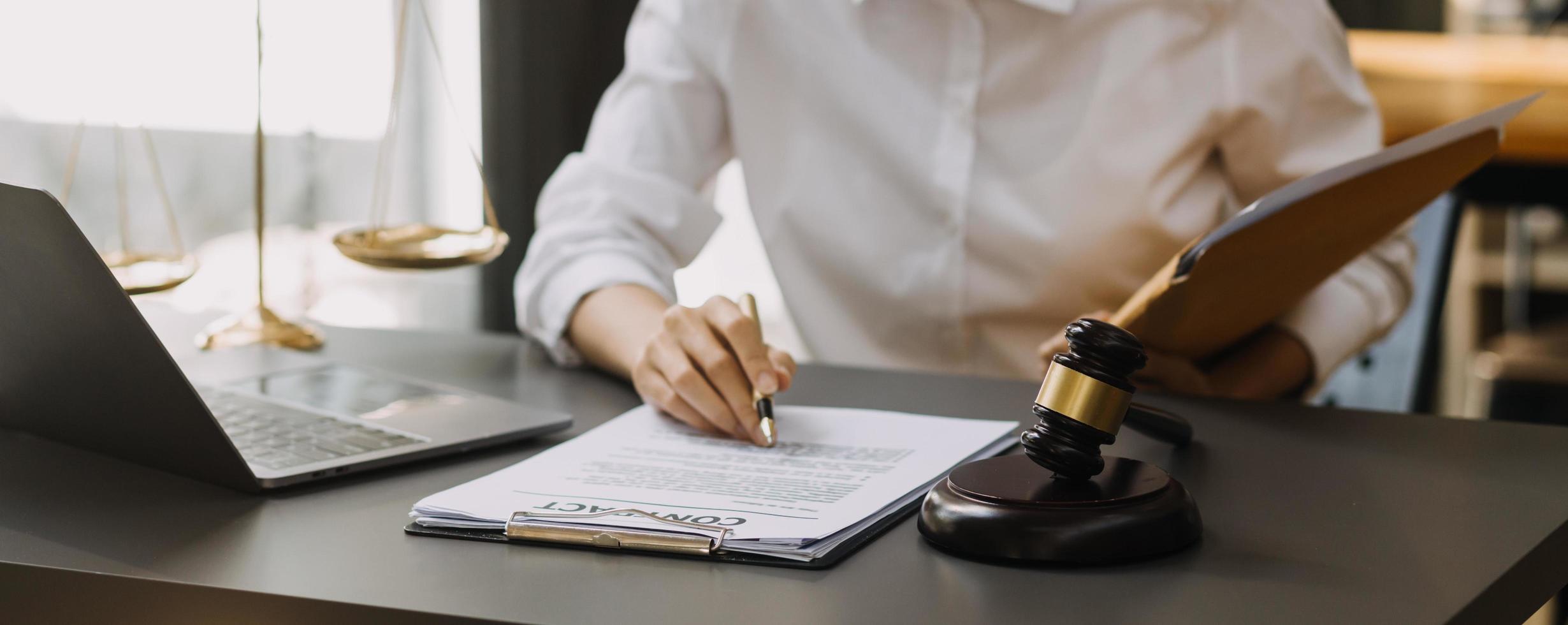 abogado masculino que trabaja con papeles de contrato y mazo de madera en tabel en la sala del
