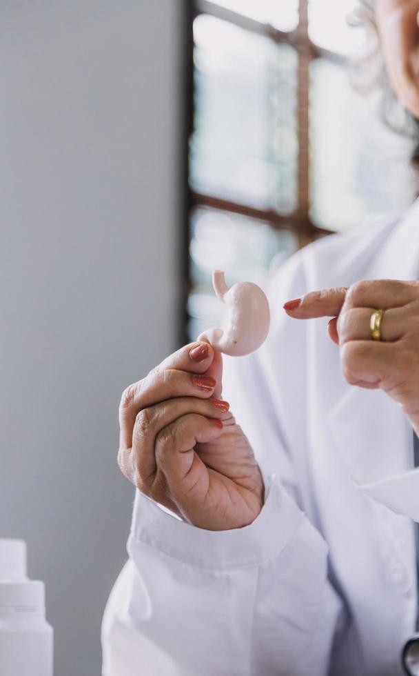 servicio de enfermería domiciliaria y cardiología asistencial a personas mayores. Primer plano de una joven doctora hispana enfermera comprobar los latidos del corazón de un hombre caucásico maduro usando un estetoscopio durante la visita foto