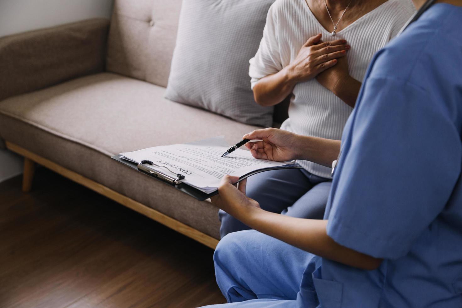 Homecare nursing service and elderly people cardiology healthcare. Close up of young hispanic female doctor nurse check mature caucasian man patient heartbeat using stethoscope during visit photo