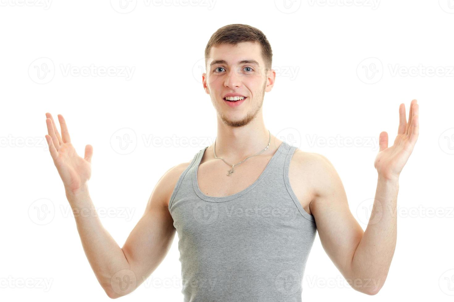 Happy young man showing something big with his hands and smiling on camera photo