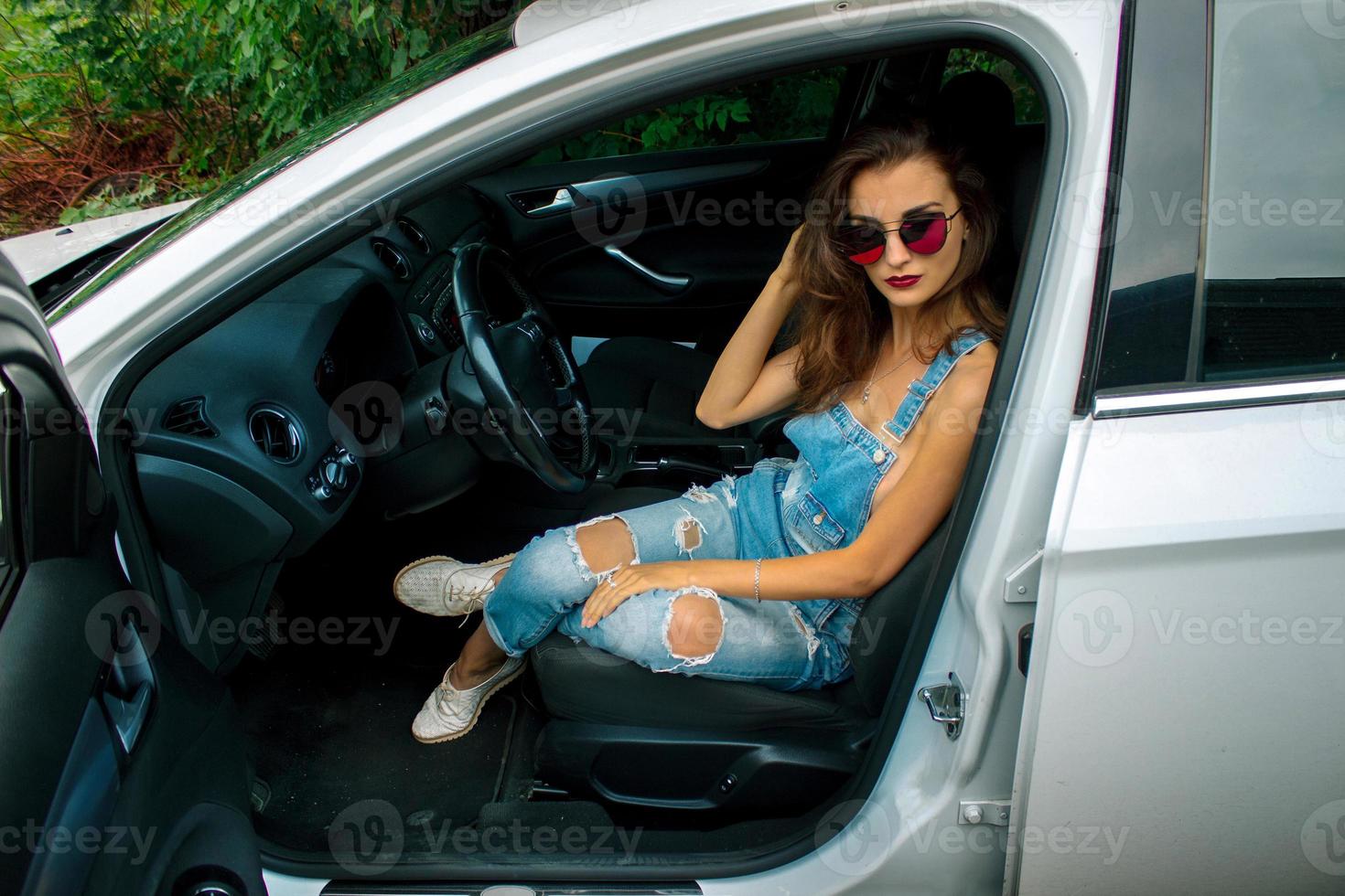 fashion beautiful women sits in the car and looks into the camera photo