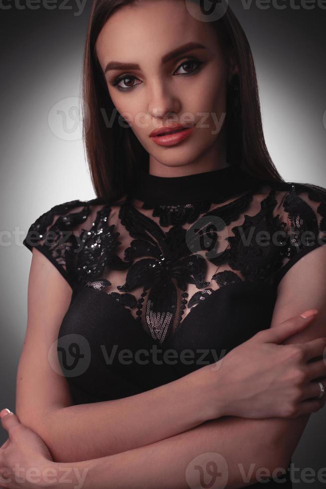 Sexy young lady in black dress in studio photo