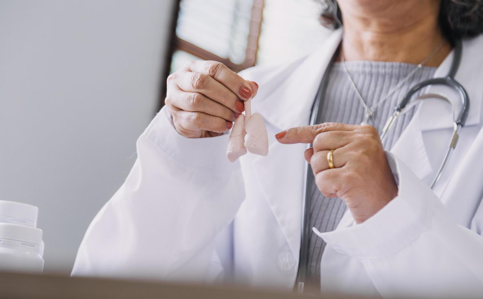 Homecare nursing service and elderly people cardiology healthcare. Close up of young hispanic female doctor nurse check mature caucasian man patient heartbeat using stethoscope during visit photo