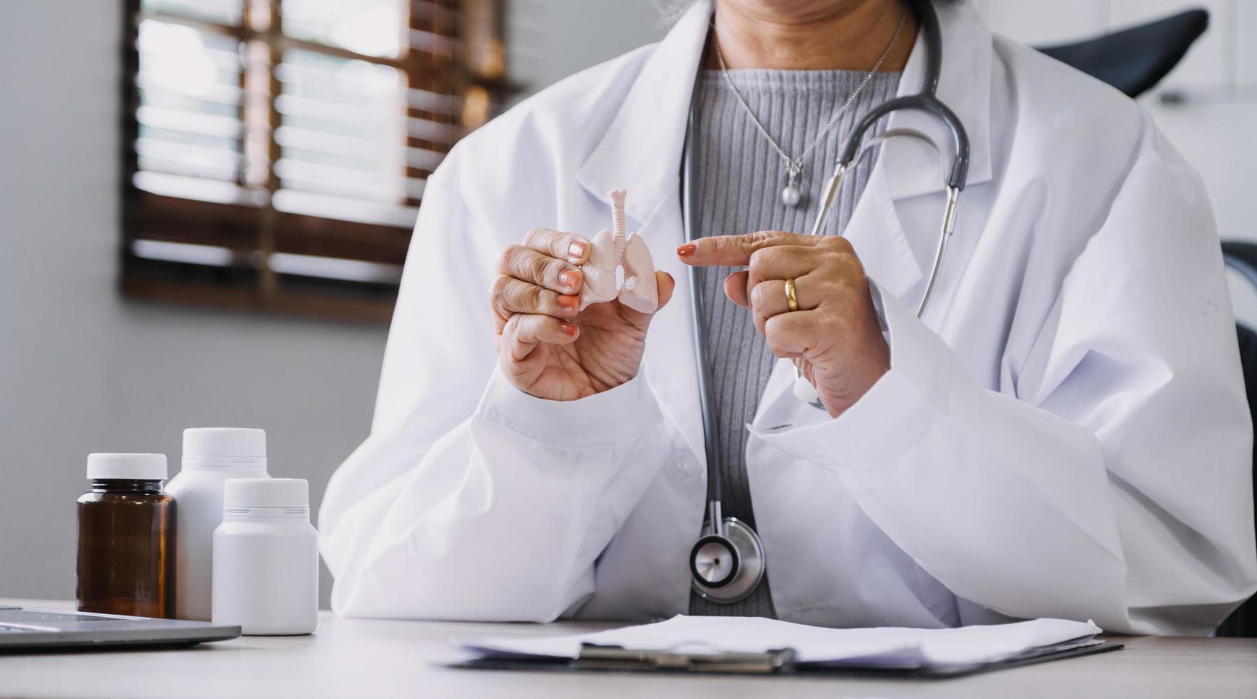 Homecare nursing service and elderly people cardiology healthcare. Close up of young hispanic female doctor nurse check mature caucasian man patient heartbeat using stethoscope during visit photo