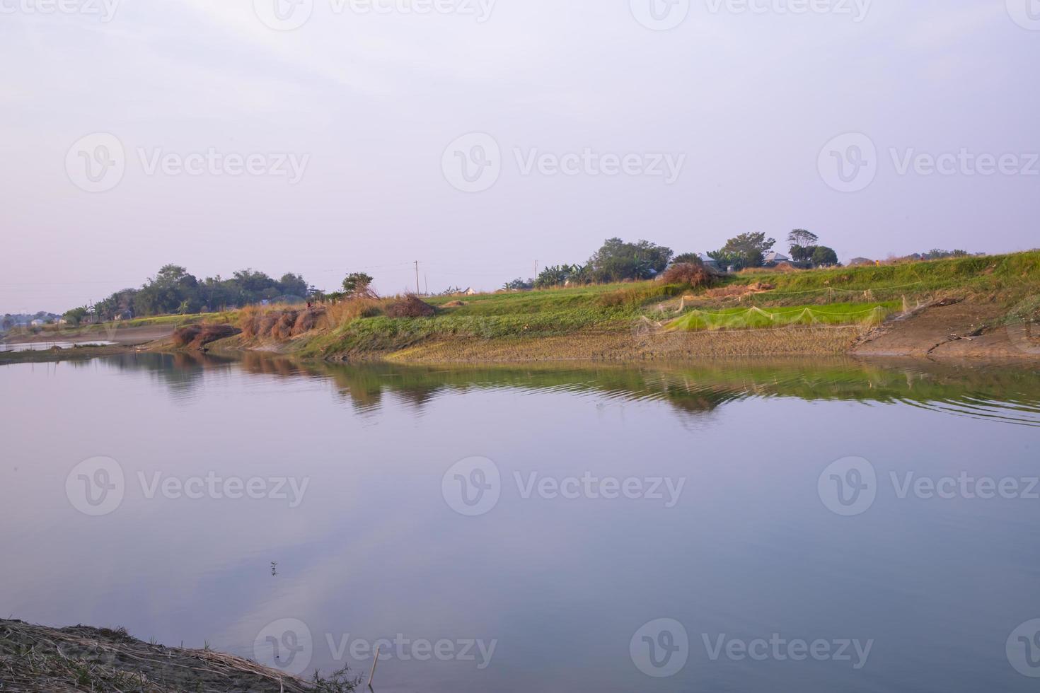 Arial View Canal with green grass and vegetation reflected in the water nearby Padma river in Bangladesh photo