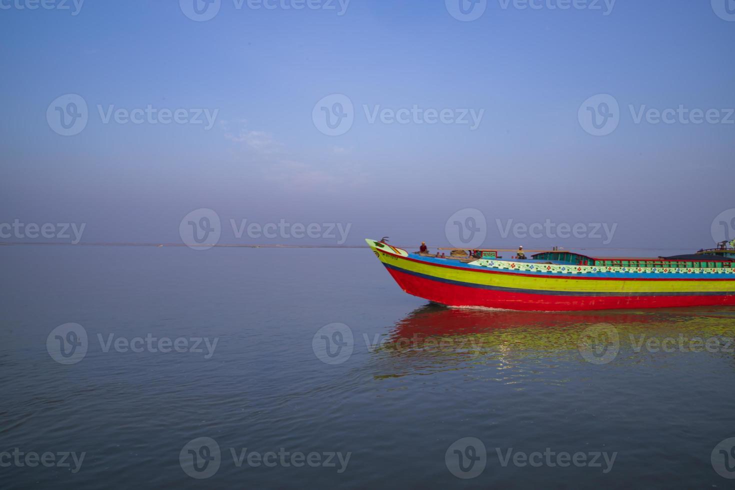 Landscape View of a small cargo ship against a blue sky on the  Padma river Bangladesh photo