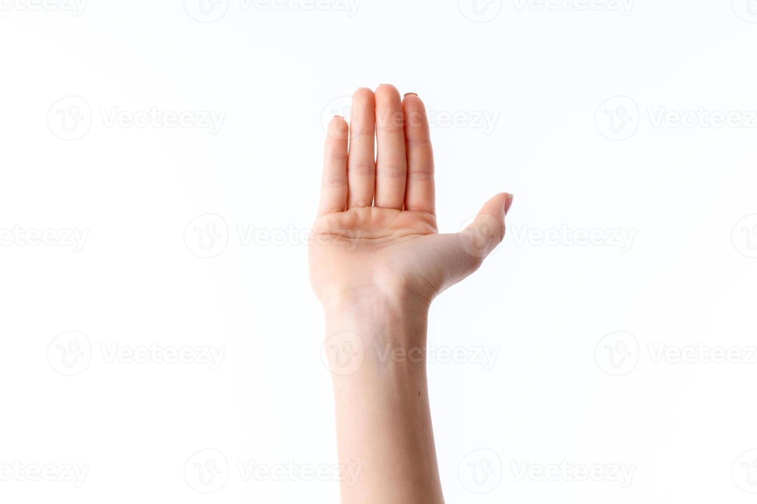 mano femenina con los dedos levantados y la palma hacia adelante desplegada foto