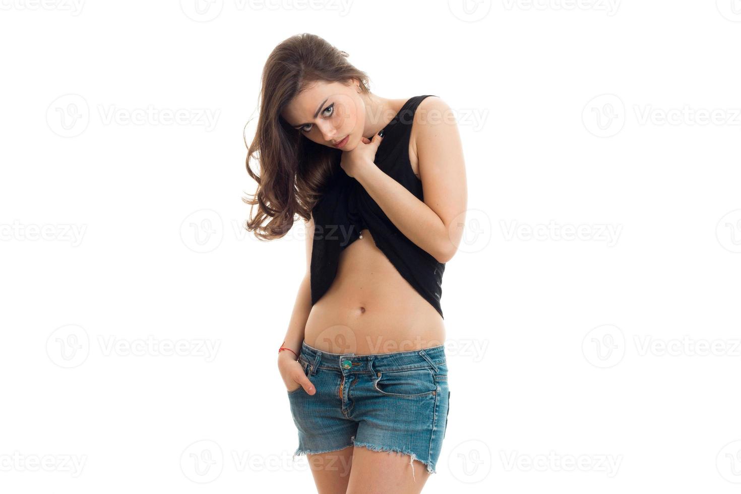 beautiful young girl stands in denim shorts and bent her head photo