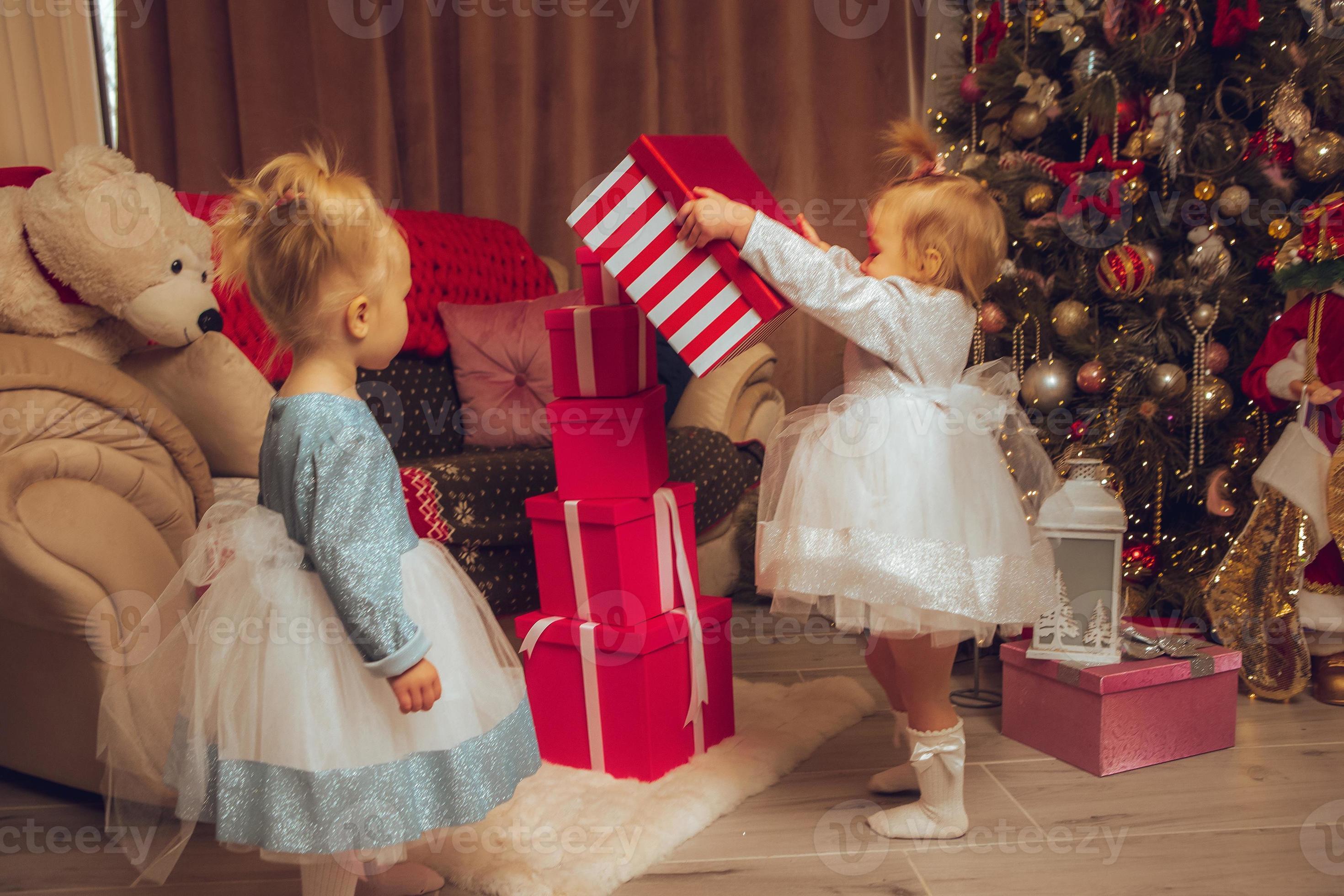 Happy Baby Sisters With A Xmas Tree From Behind At Home 16342828 Stock happy-baby-sisters-with-a-xmas-tree-from-behind-at-home-16342828-stock