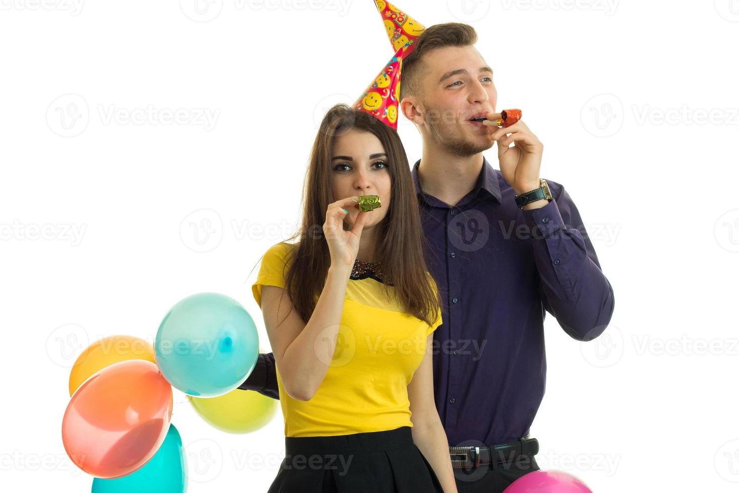 pretty funny girl and the guy holding balloons and blow horns close-up photo