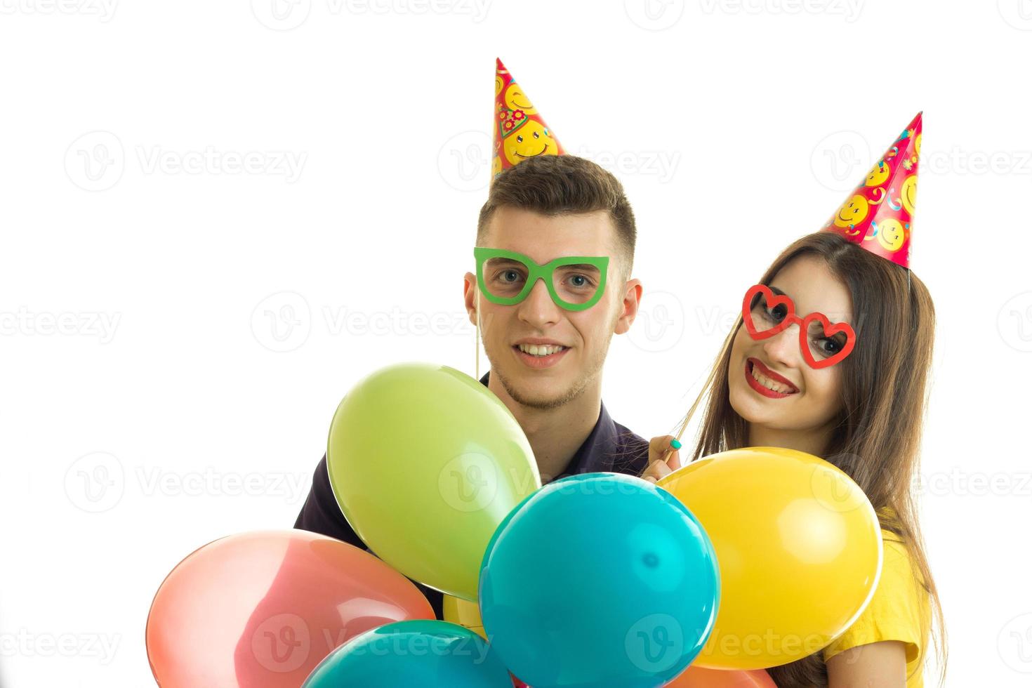 el joven sonriente y la alegre chica con gafas de colores y globos foto