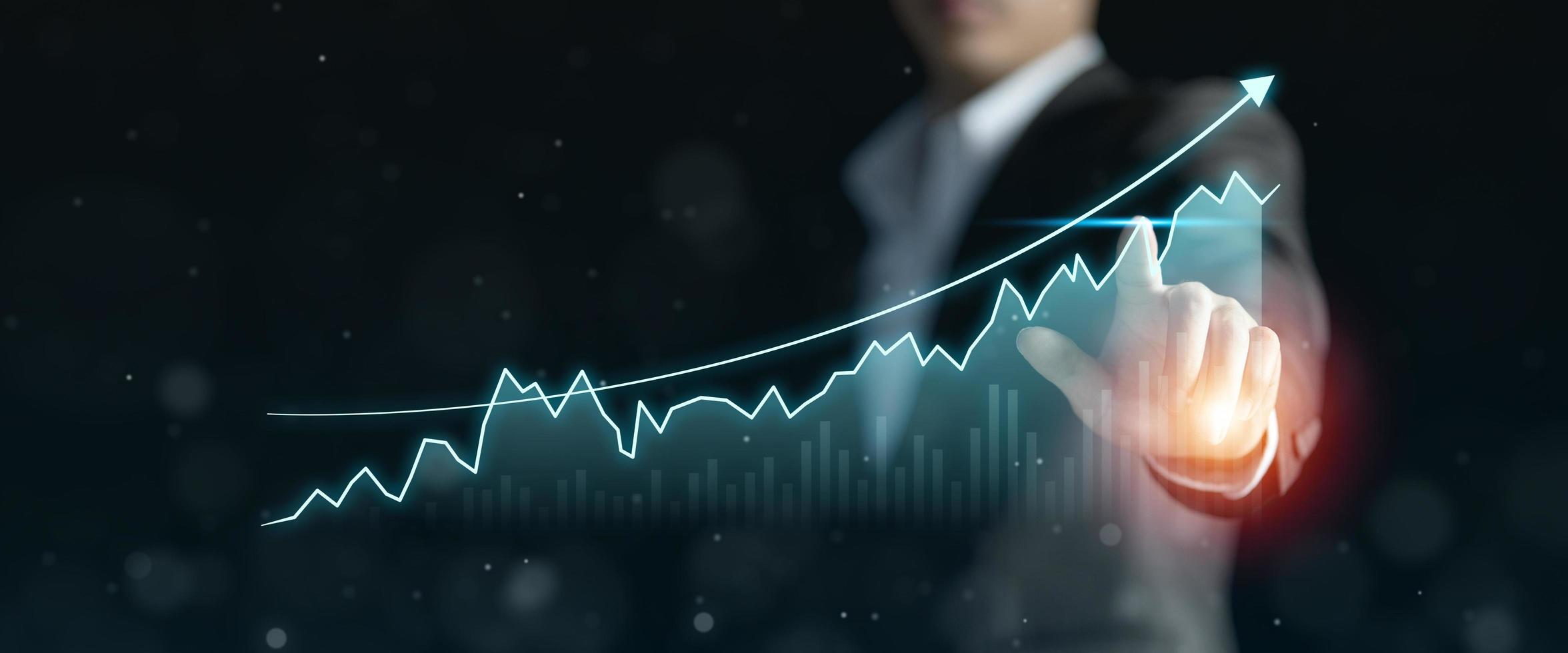 mano de hombre de negocios que señala el gráfico hacia el éxito, el crecimiento del concepto financiero empresarial, el gráfico de inversión financiera y el análisis del plan del mercado de valores foto