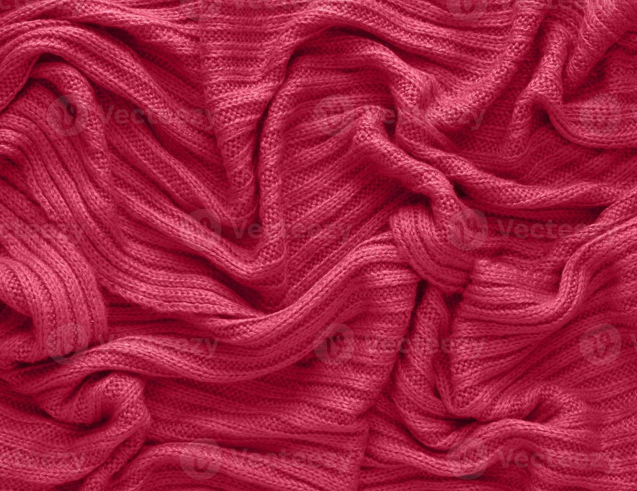 Texture of smooth knitted sweater with pattern. Handmade knitting wool or cotton fabric texture. Background of Large knit pattern with knitting needle or crochet. Color Of The Year 2023 - Viva Magenta photo