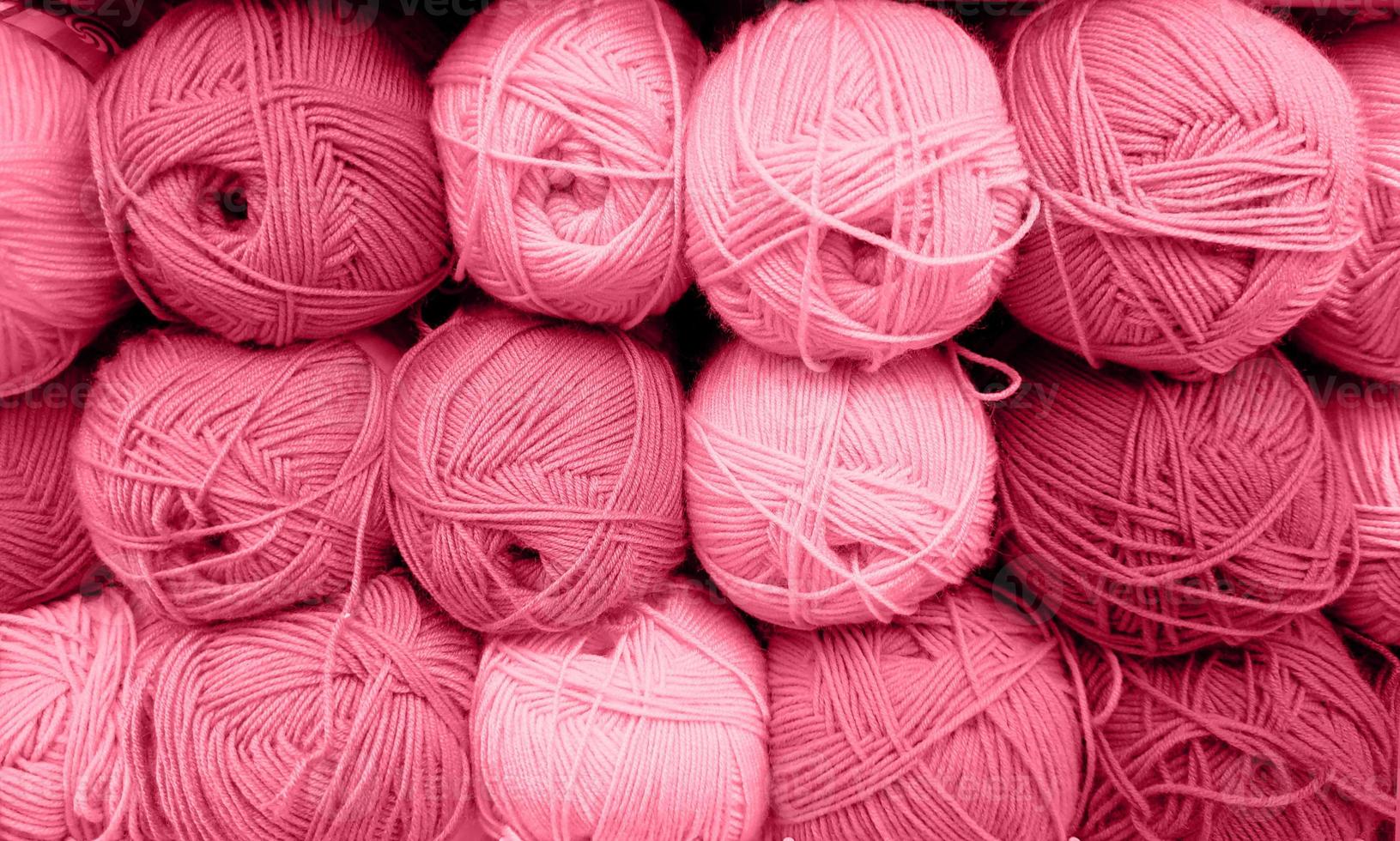 Yarn Balls Wool in a Fabric Shop. Background from colored acrylic yarn. Skeins of thread close-up. Materials for needlework, for knitting and crocheting. Color Of The Year 2023 - Viva Magenta photo