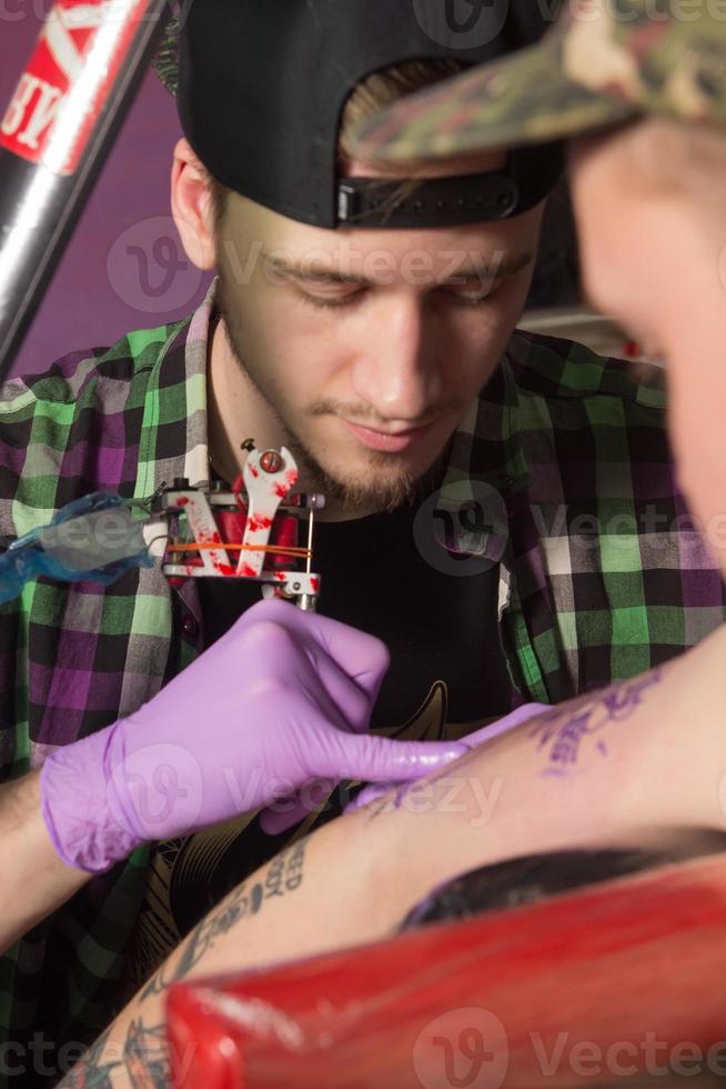 Tatooer is making tatoo photo