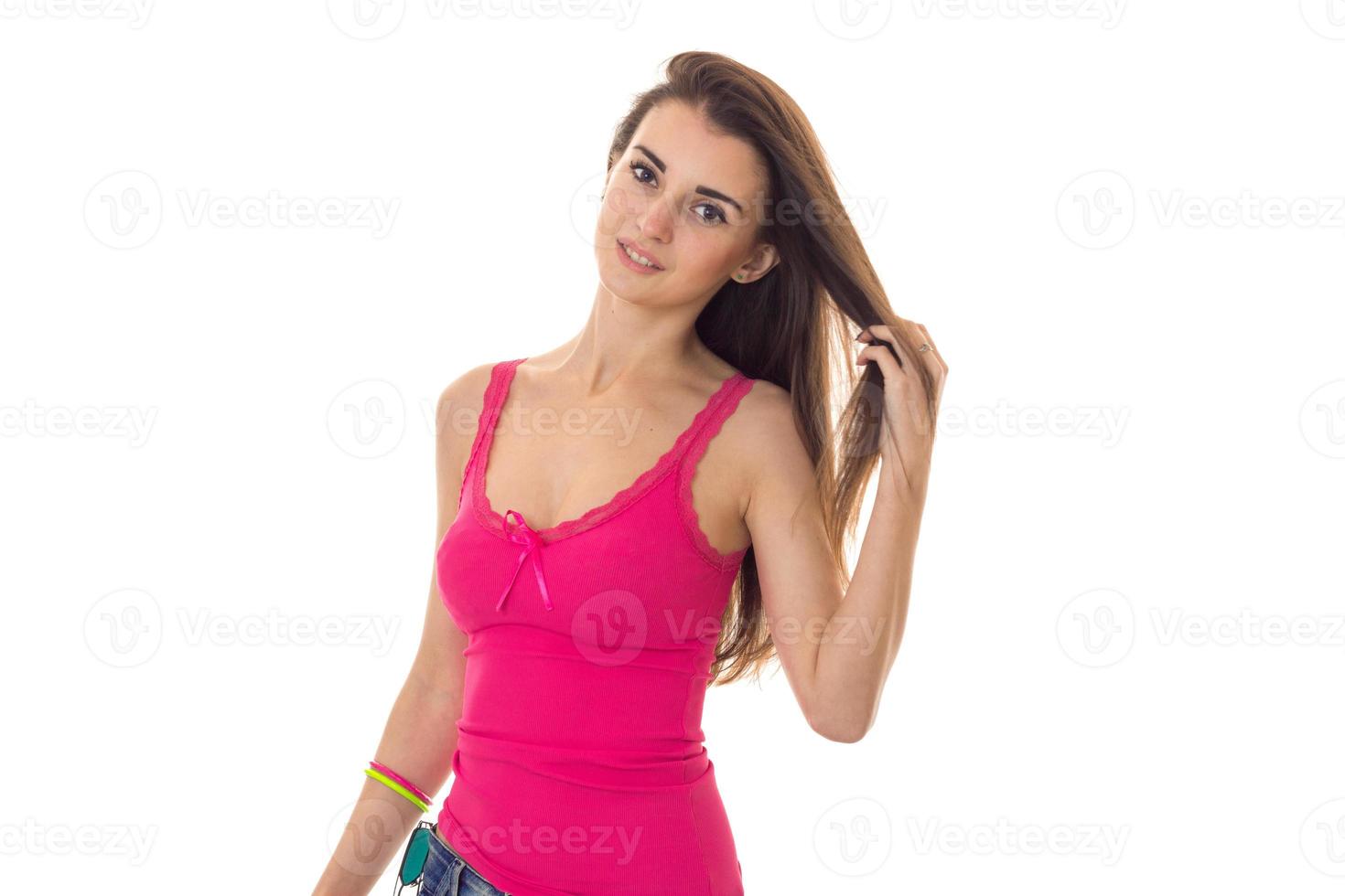 beautiful young brunette woman in pink shirt posing on camera isolated on white background photo