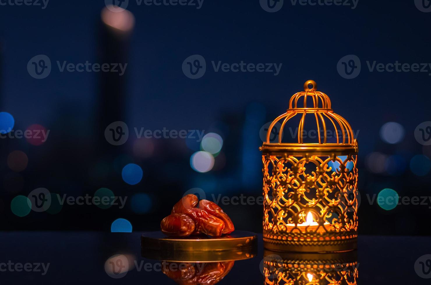 Golden lantern and dates fruit with night sky and city bokeh light background for the Muslim feast of the holy month of Ramadan Kareem. photo