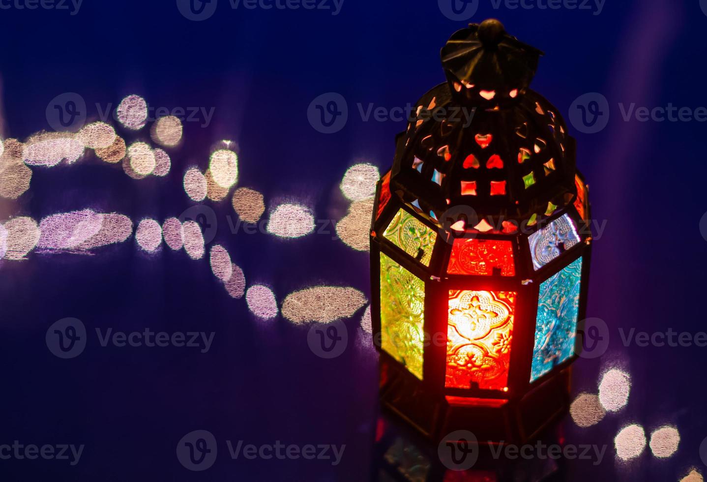 Selective focus of lantern on blue background with reflection from bokeh light for the Muslim feast of the holy month of Ramadan Kareem. photo