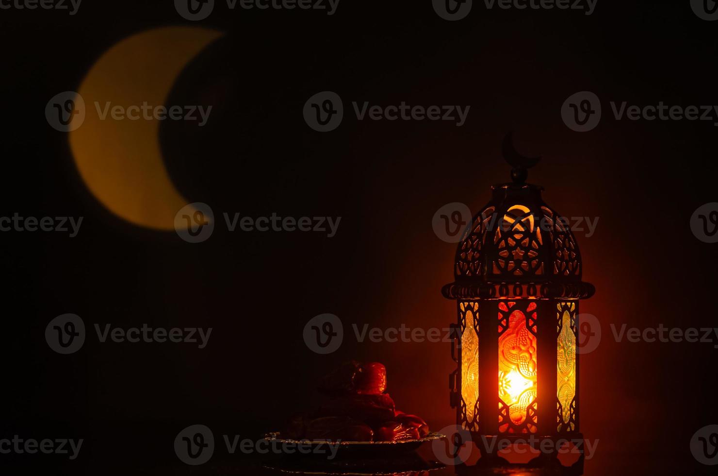 linterna y plato pequeño de dátiles con forma de luna de luz en el fondo para la fiesta musulmana del mes sagrado de ramadán kareem. foto