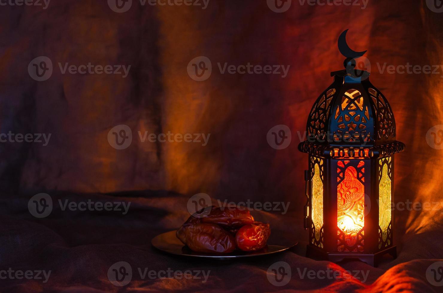 Black lantern and dates fruit on dark background for the Muslim feast of the holy month of Ramadan Kareem. photo