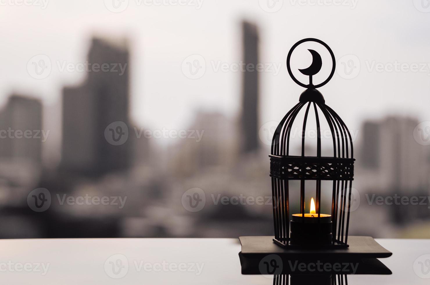 Lantern that have moon symbol on top with city background for the Muslim feast of the holy month of Ramadan Kareem. photo