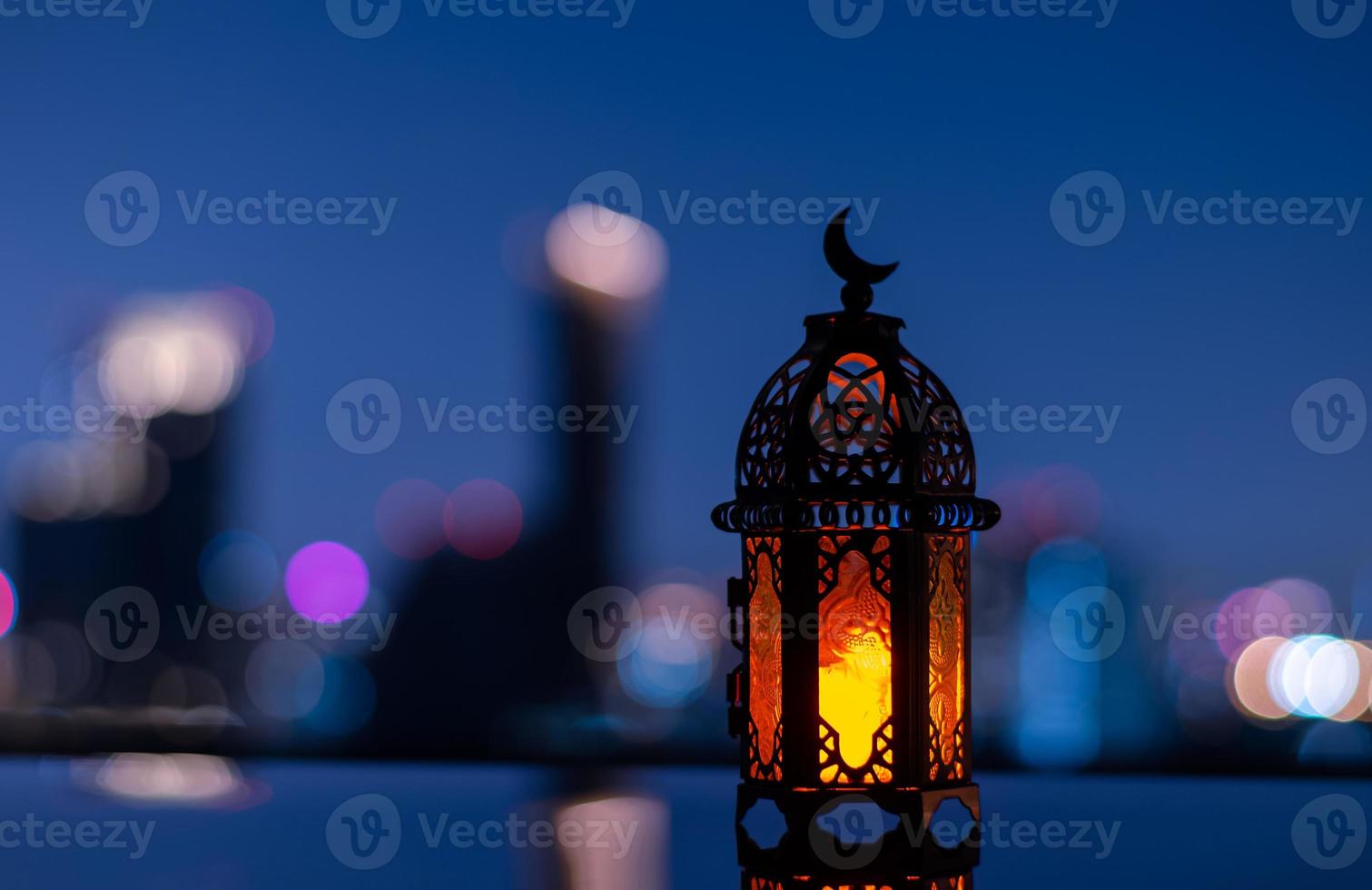 Selective focus of lantern that have moon symbol on top with city background for the Muslim feast of the holy month of Ramadan Kareem. photo