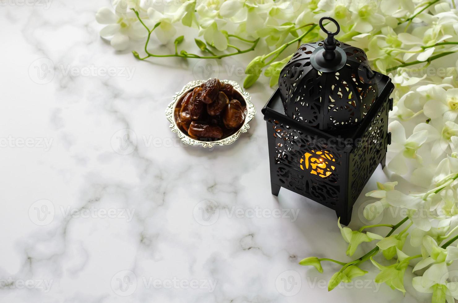 Lantern and dates fruit on marble with white orchid flower for the Muslim feast of the holy month of Ramadan Kareem. photo