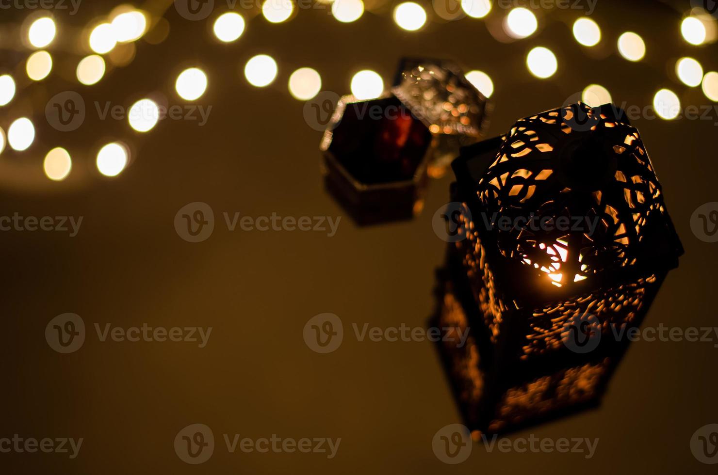 Selective focus of lantern with dates fruit reflection from bokeh light for the Muslim feast of the holy month of Ramadan Kareem. photo